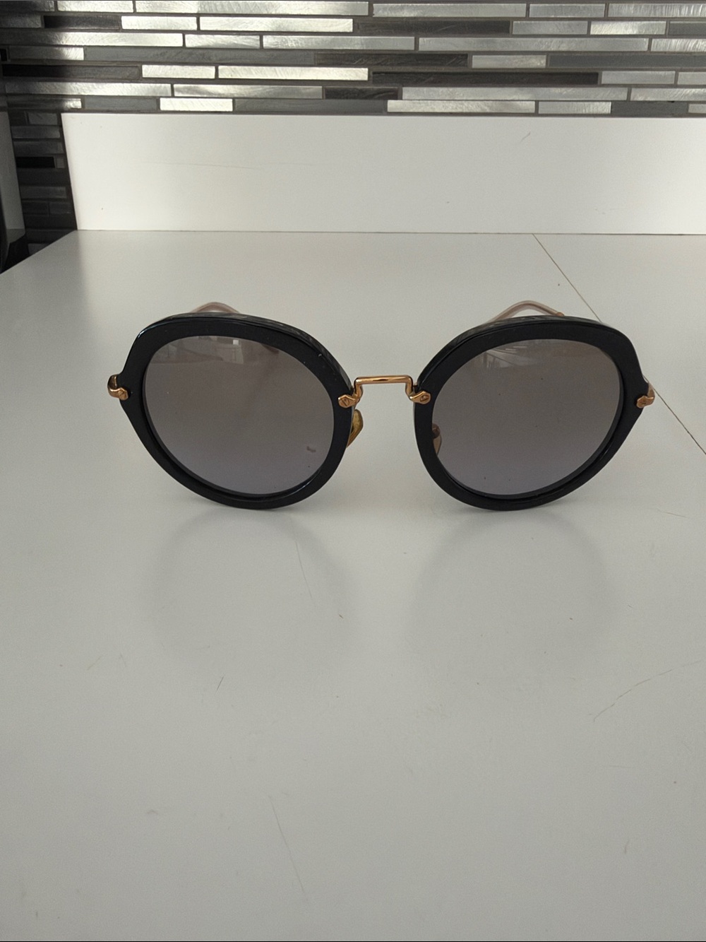 Miu Miu Black Frame Sunglasses with Gold Accents and Gray Lenses